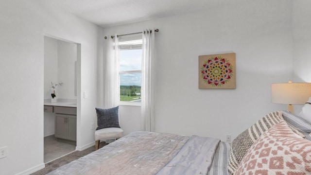 bedroom featuring ensuite bath and multiple windows