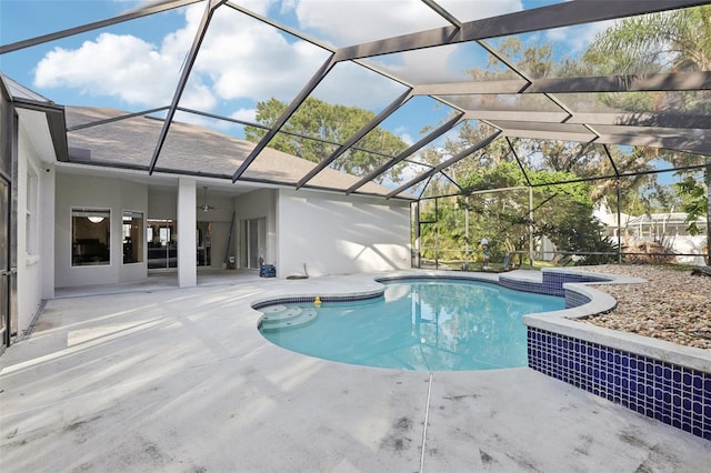 view of pool with glass enclosure and a patio