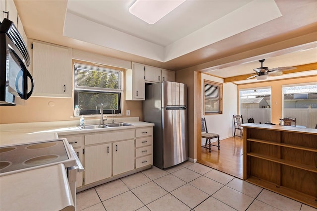 kitchen with light hardwood / wood-style flooring, sink, a tray ceiling, and stainless steel fridge