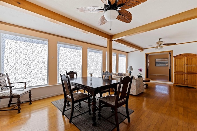 dining space featuring beam ceiling, ceiling fan, and wood-type flooring