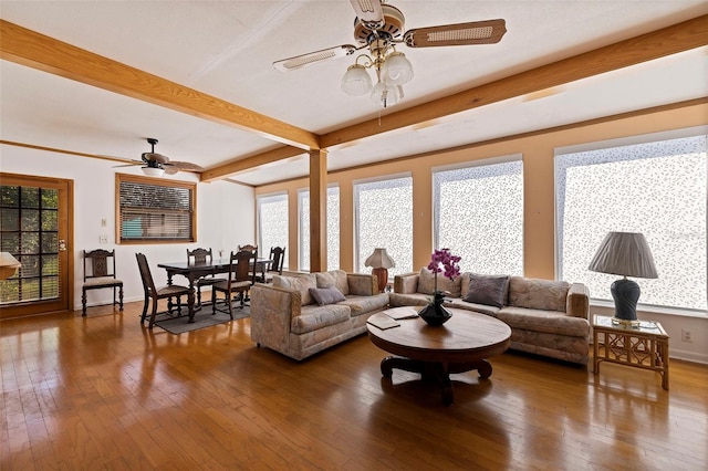 living room with beam ceiling, dark wood-type flooring, and a healthy amount of sunlight