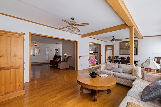 living room featuring hardwood / wood-style floors, beamed ceiling, and ceiling fan