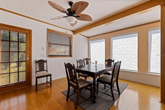 dining area with beamed ceiling, light hardwood / wood-style flooring, ceiling fan, and crown molding