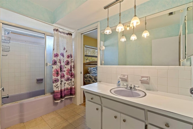 bathroom featuring tile patterned flooring, backsplash, bath / shower combo with glass door, vanity, and tile walls