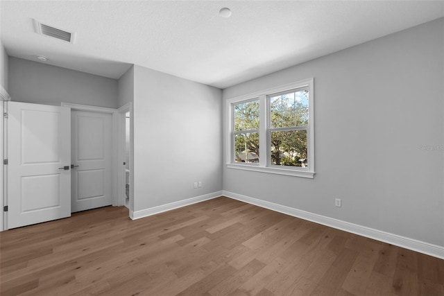 unfurnished bedroom featuring a textured ceiling and light wood-type flooring