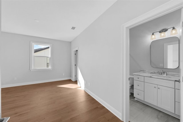 bathroom with toilet, vanity, and hardwood / wood-style flooring