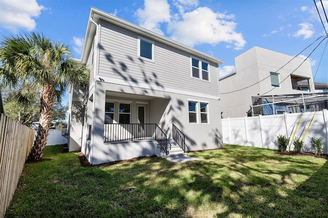 rear view of property featuring a lawn