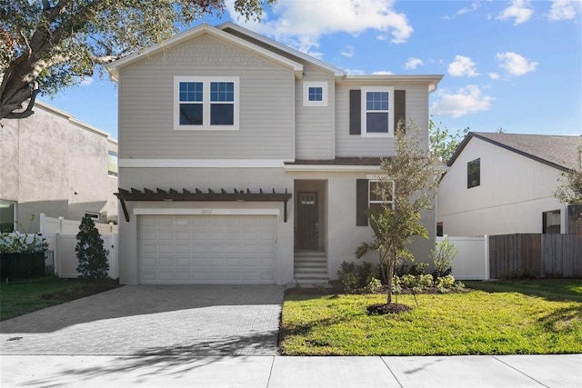 view of property featuring a garage and a front lawn