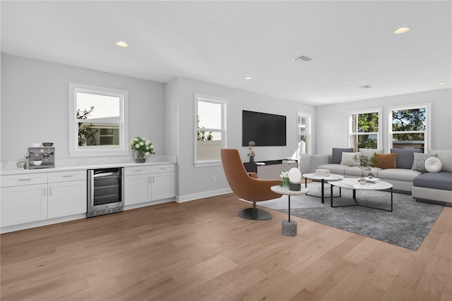 living room with light wood-type flooring and beverage cooler