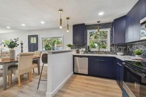 kitchen with dishwasher, blue cabinets, kitchen peninsula, and light wood-type flooring