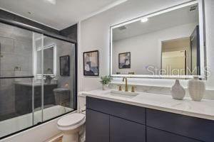 full bathroom with toilet, vanity, and shower / bath combination with glass door