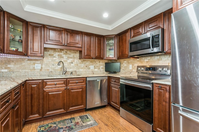 kitchen with light hardwood / wood-style floors, crown molding, sink, and appliances with stainless steel finishes