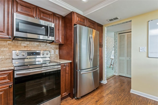 kitchen featuring light stone countertops, appliances with stainless steel finishes, tasteful backsplash, crown molding, and dark hardwood / wood-style floors