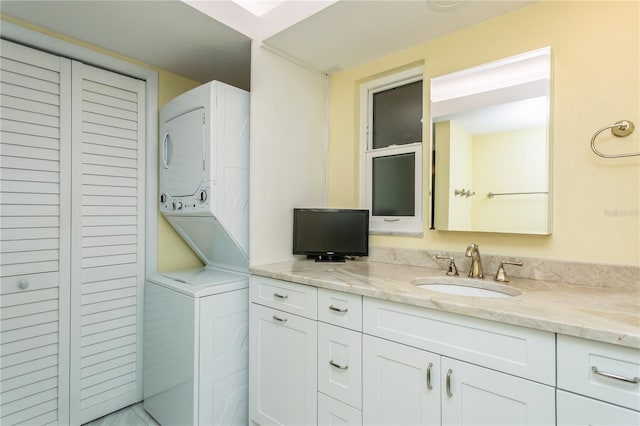 bathroom with stacked washer / dryer and vanity