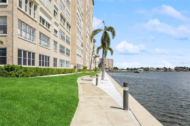 dock area with a yard and a water view