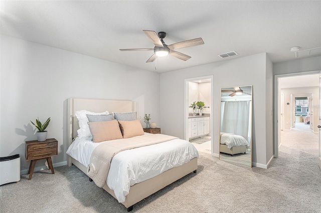 bedroom featuring connected bathroom, light carpet, and ceiling fan