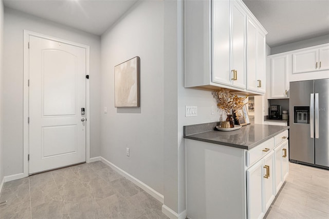 kitchen with stainless steel fridge with ice dispenser and white cabinets