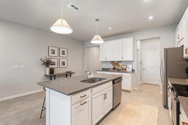 kitchen featuring an island with sink, sink, stainless steel dishwasher, and white cabinets