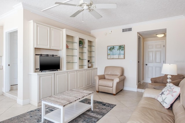 living room with ceiling fan, a textured ceiling, light tile patterned floors, and ornamental molding