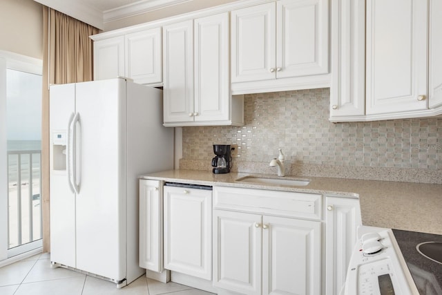 kitchen featuring white cabinets, ornamental molding, sink, and white refrigerator with ice dispenser