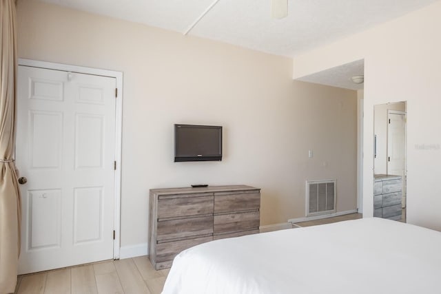 bedroom with ceiling fan, a textured ceiling, a closet, and light hardwood / wood-style flooring