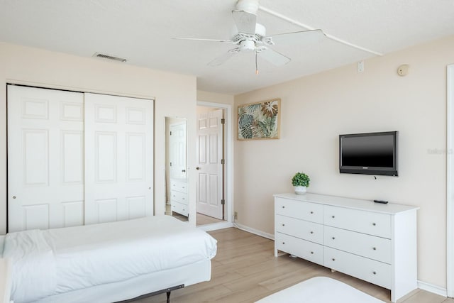 bedroom featuring light wood-type flooring, ceiling fan, and a closet