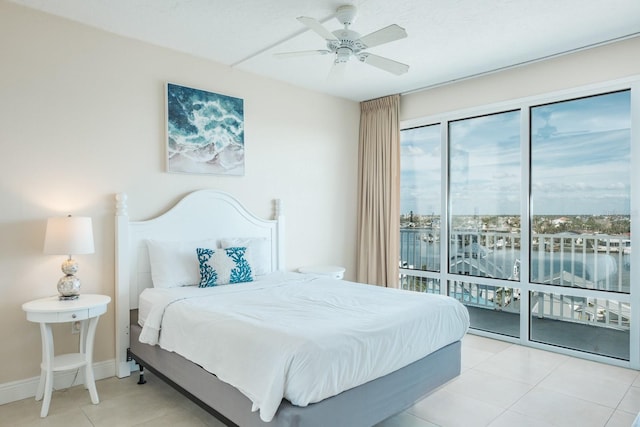 tiled bedroom with ceiling fan and a water view