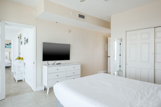 bedroom with light tile patterned floors, ceiling fan, and a closet