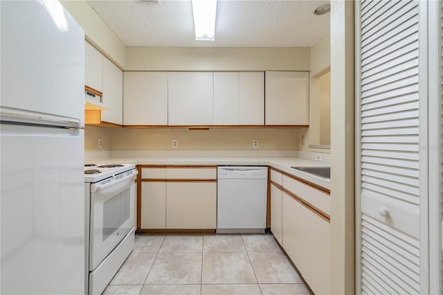 kitchen featuring extractor fan, white cabinetry, a textured ceiling, and white appliances