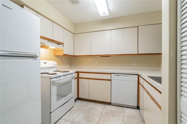 kitchen with light tile patterned flooring, sink, a textured ceiling, white appliances, and white cabinets