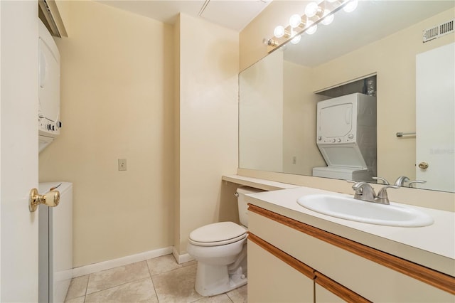 bathroom featuring vanity, stacked washer and dryer, tile patterned floors, and toilet