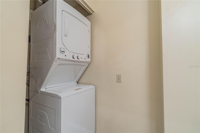 washroom with stacked washing maching and dryer