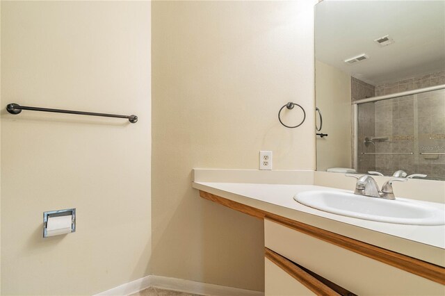 bathroom featuring walk in shower and vanity