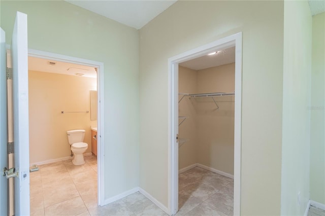 bathroom with toilet, vanity, and tile patterned flooring