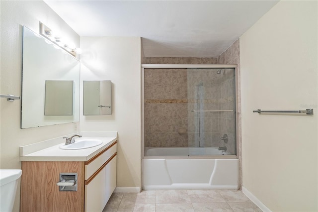 full bathroom with vanity, bath / shower combo with glass door, tile patterned flooring, and toilet