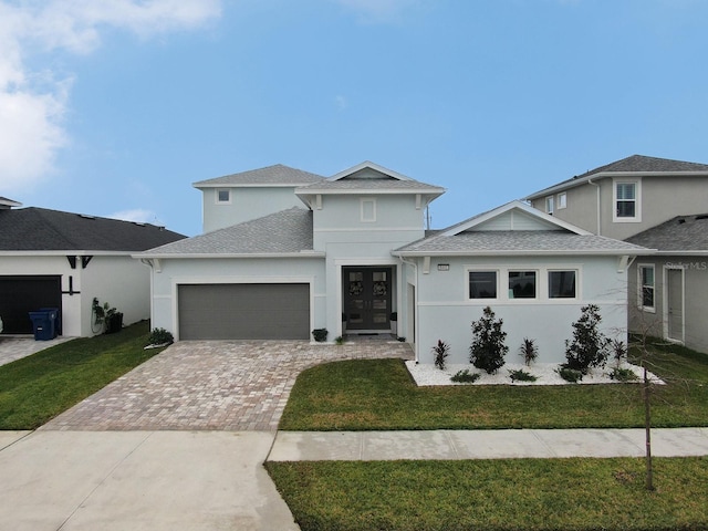 view of front of property featuring a garage, french doors, and a front yard