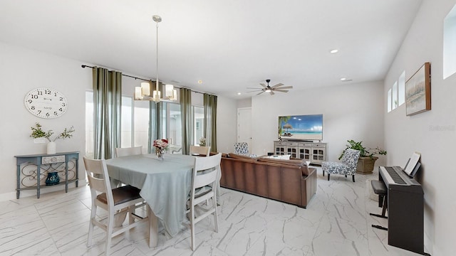 dining room with ceiling fan with notable chandelier