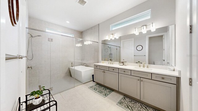 bathroom featuring tile patterned flooring, vanity, and plus walk in shower