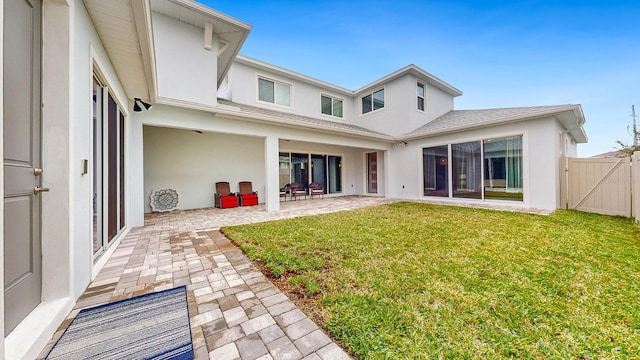 rear view of house with a patio and a yard