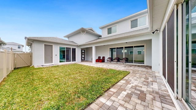 back of property featuring a patio area and a lawn