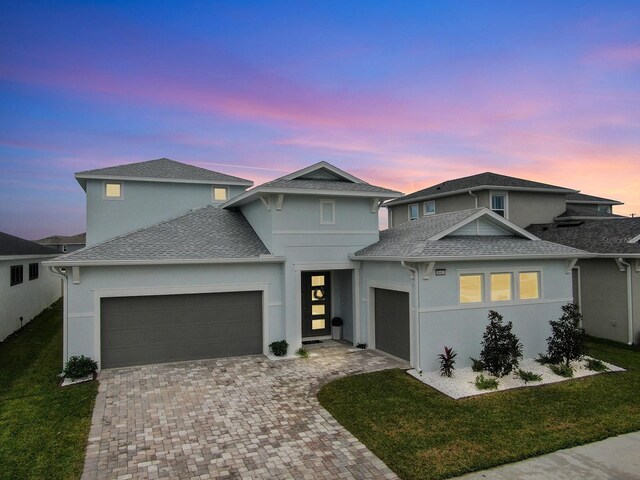 view of front facade with a garage and a lawn