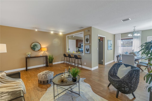 living room with hardwood / wood-style floors and a chandelier