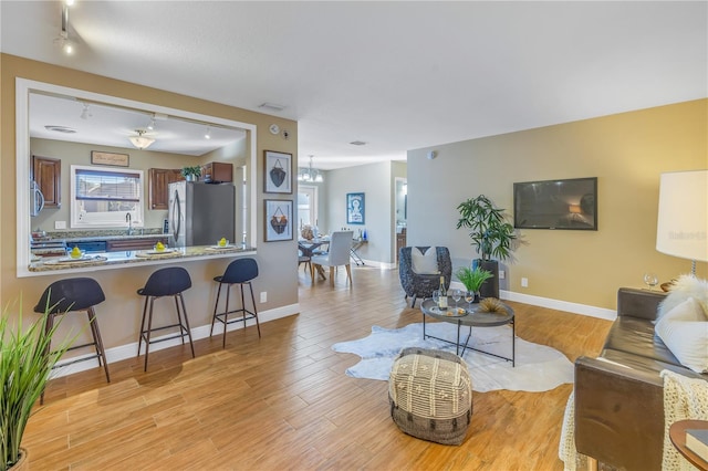 living room featuring a notable chandelier and light hardwood / wood-style flooring