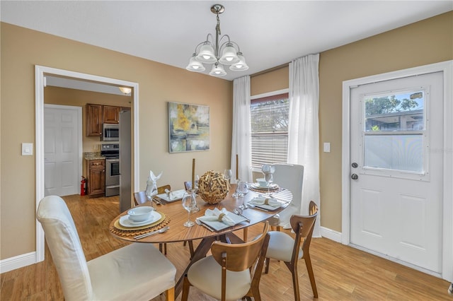 dining space featuring a chandelier and light hardwood / wood-style flooring