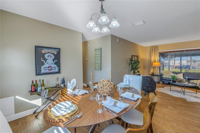 dining space with a notable chandelier and hardwood / wood-style flooring