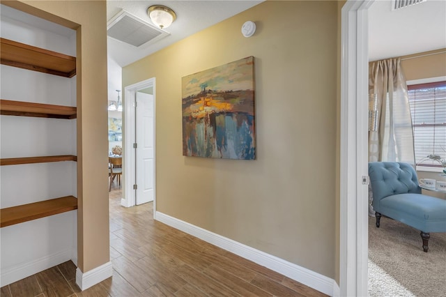 corridor with hardwood / wood-style flooring