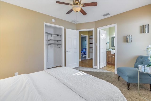 bedroom featuring ensuite bath, ceiling fan, a spacious closet, light hardwood / wood-style flooring, and a closet