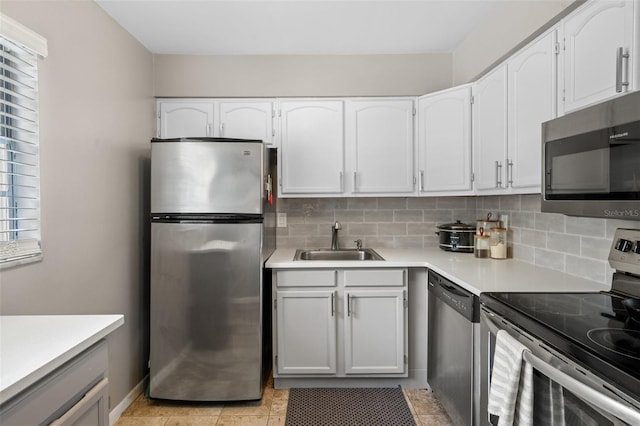 kitchen with white cabinets, decorative backsplash, sink, and stainless steel appliances