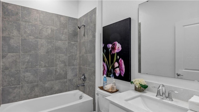 full bathroom featuring vanity, tiled shower / bath combo, and toilet