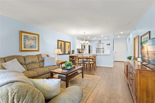 living room with light hardwood / wood-style flooring and a notable chandelier